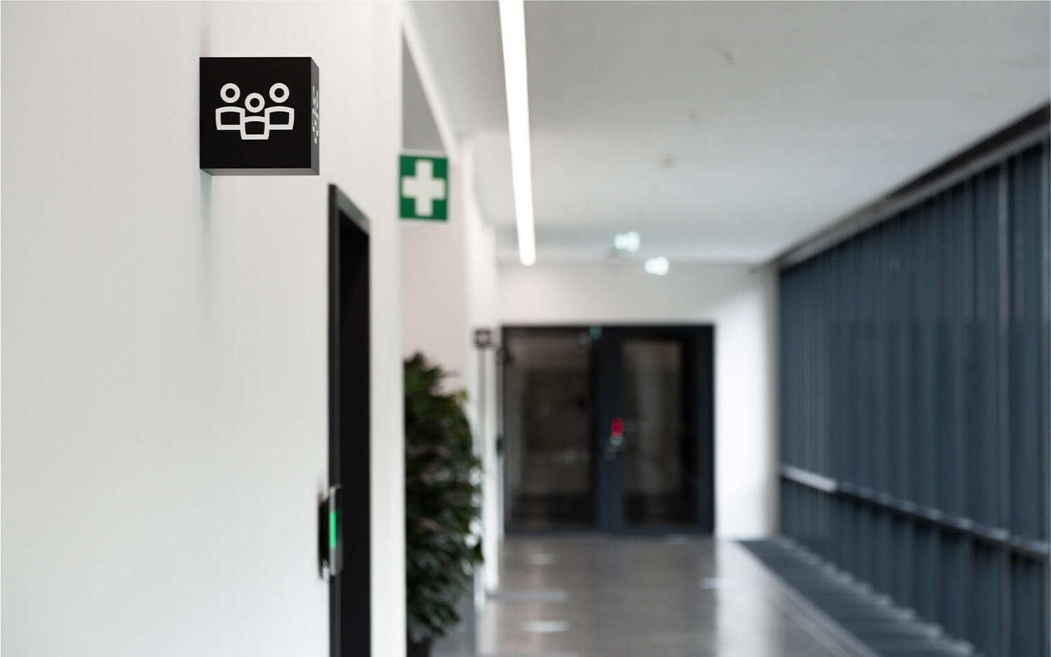 This photo shows a cube hanging in the hallway with the meeting room pictogram.