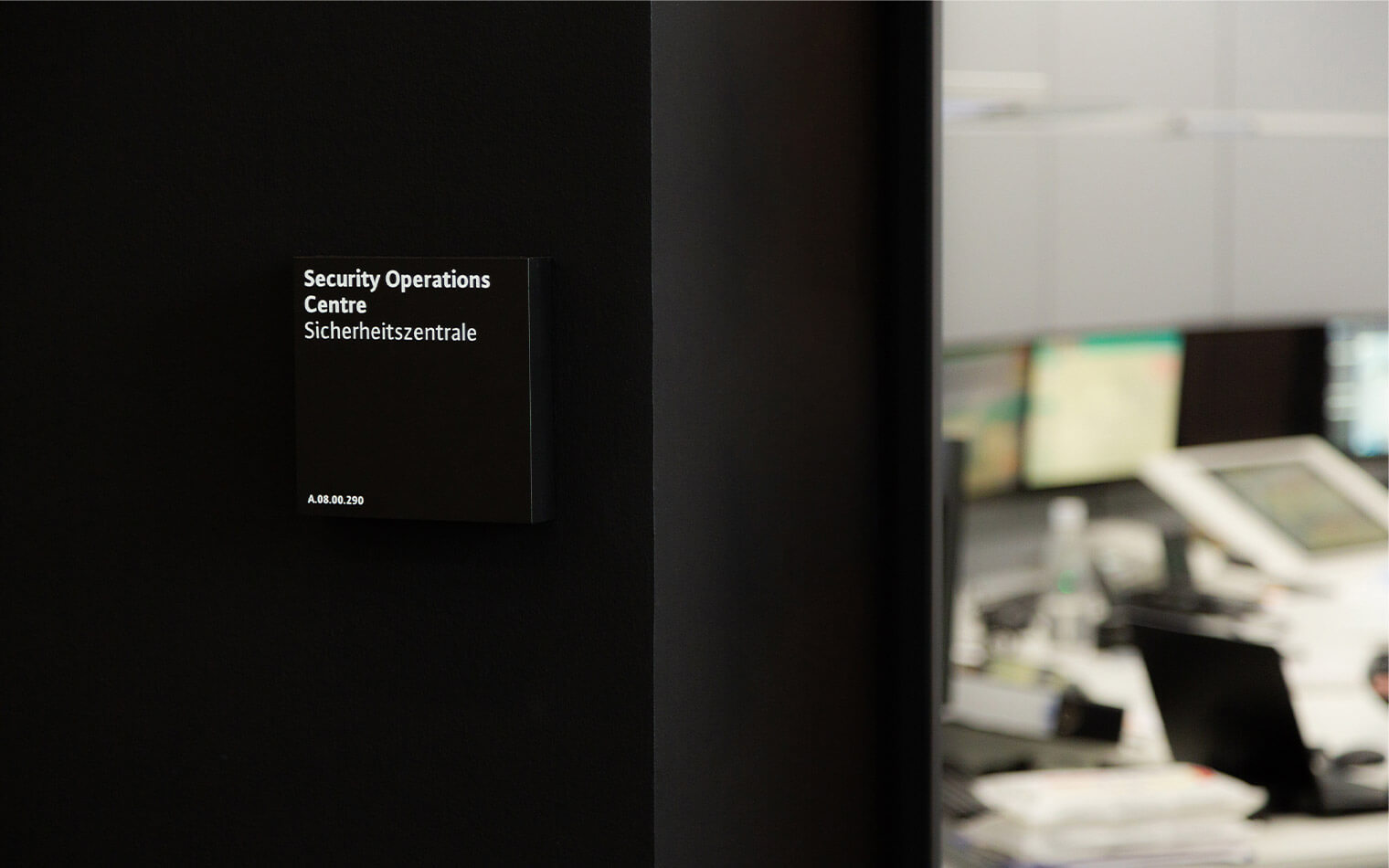 Auf diesem Foto ist das Türschild der Sicherheitszentrale auf einem schwarzen Hintergrund zu sehen.