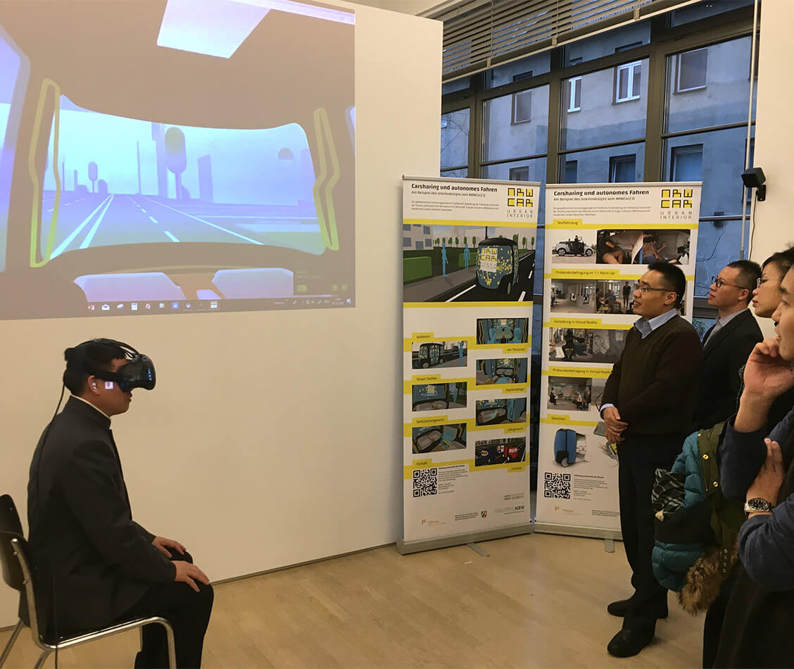 Auf diesem Bild testet der Vorsitzende der Stadtkommission für Wirtschaft und Informatik in Shanghai mithilfe von Virtual Reality eine Fahrt mit dem NRWCar2.0.